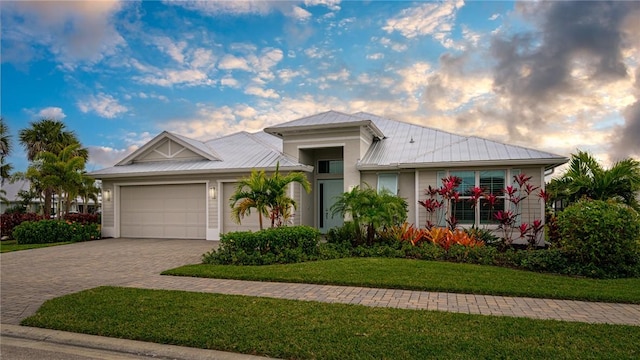 view of front facade with a yard and a garage