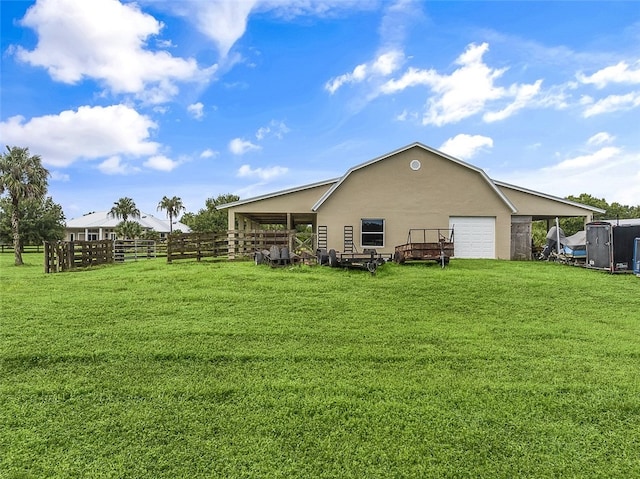 rear view of property with a garage and a yard