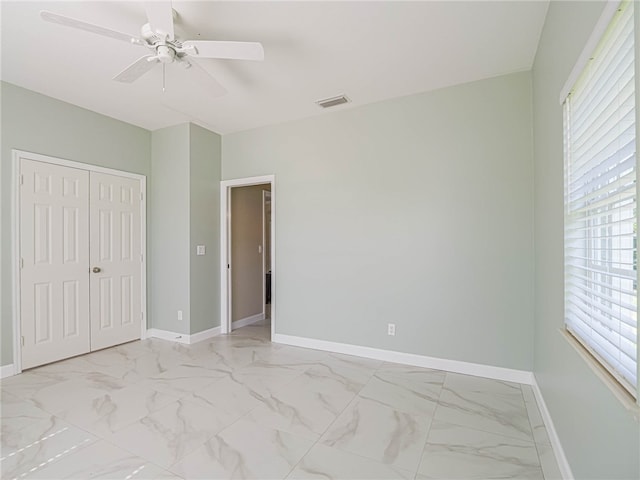 unfurnished bedroom with multiple windows, a closet, and ceiling fan