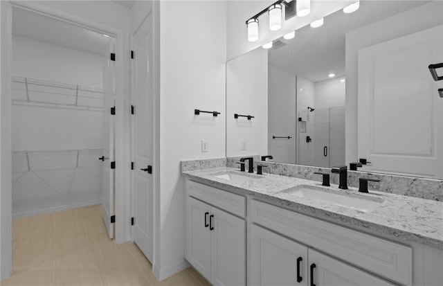 1209 Harper Way Unit 008, Vero Beach, FL 32960 - bathroom featuring a stall shower, a walk in closet, and double vanity