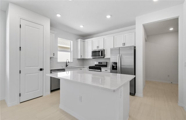 1209 Harper Way Unit 008, Vero Beach, FL 32960 - kitchen featuring stainless steel appliances, white cabinetry, a kitchen island, backsplash, and recessed lighting