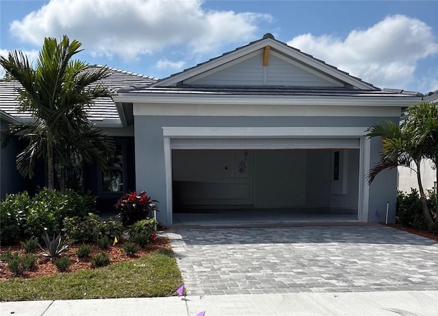 1209 Harper Way Unit 009, Vero Beach, FL 32960 - view of front of property featuring decorative driveway, stucco siding, and an attached garage