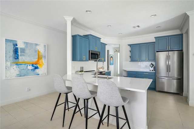 kitchen featuring a kitchen bar, blue cabinets, kitchen peninsula, stainless steel appliances, and backsplash