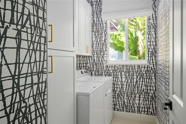 laundry room with separate washer and dryer and cabinets