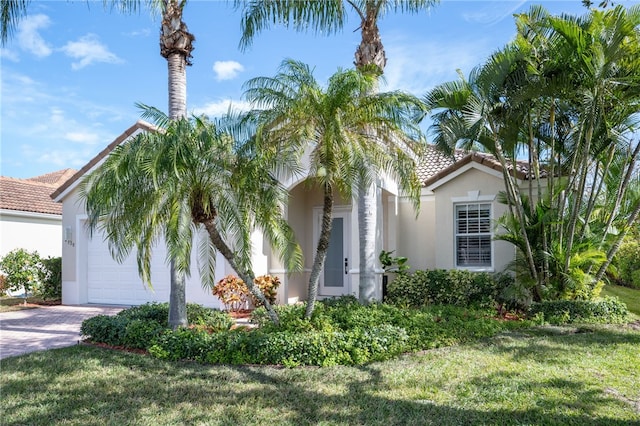 mediterranean / spanish house with a garage and a front lawn