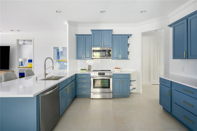 kitchen featuring appliances with stainless steel finishes, tasteful backsplash, blue cabinets, crown molding, and a center island with sink