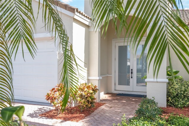 property entrance featuring a garage and french doors