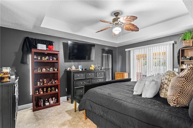 bedroom featuring carpet floors, a ceiling fan, baseboards, and a raised ceiling