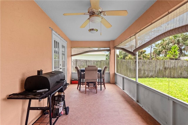sunroom / solarium with a ceiling fan, french doors, and outdoor dining area