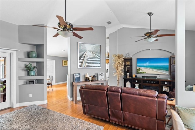 living area featuring light wood-style floors, ceiling fan, vaulted ceiling, and visible vents