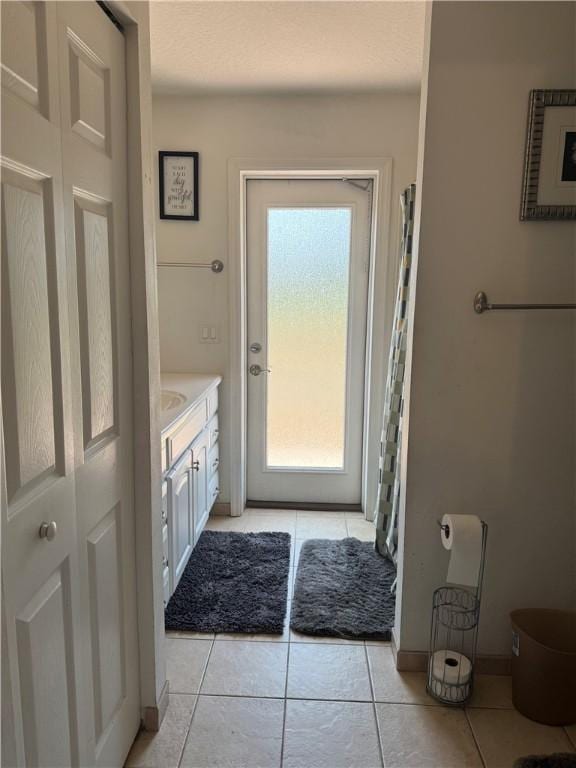 bathroom featuring baseboards, tile patterned flooring, and vanity