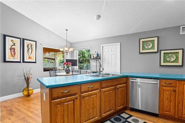 kitchen with brown cabinets, a sink, light wood-style flooring, stainless steel dishwasher, and vaulted ceiling