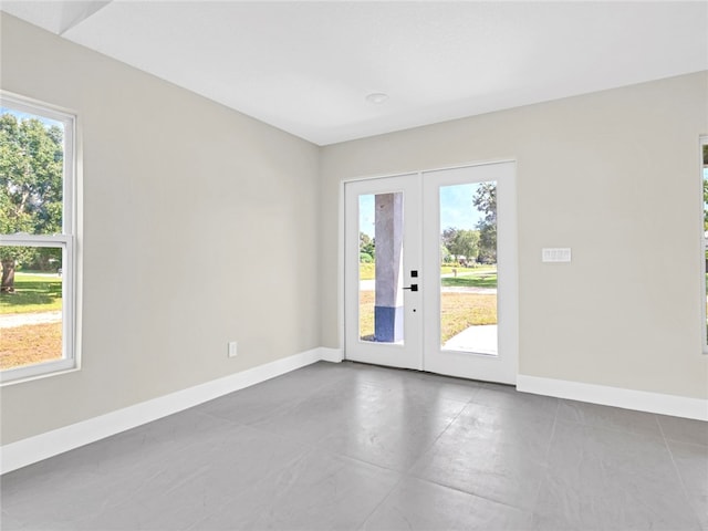 unfurnished room with french doors, tile patterned floors, and a wealth of natural light