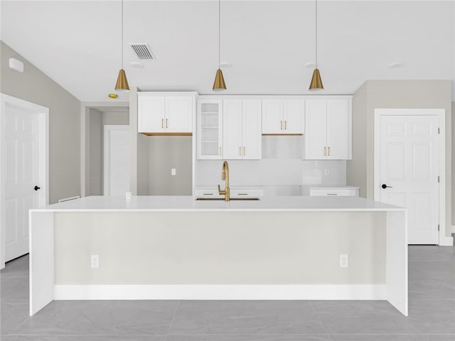 kitchen featuring sink, a kitchen island with sink, and hanging light fixtures