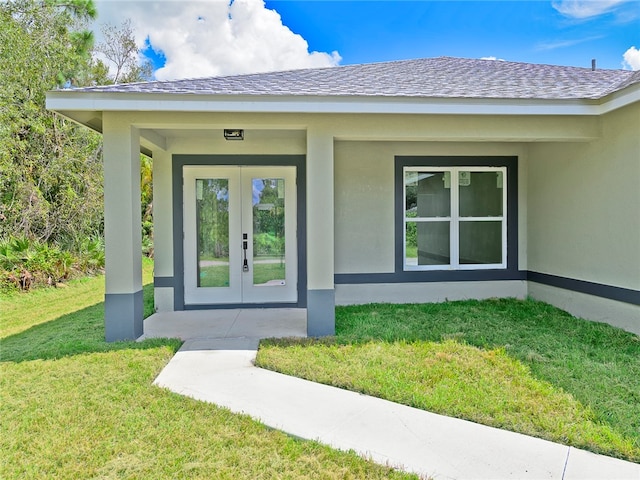 entrance to property with covered porch and a yard