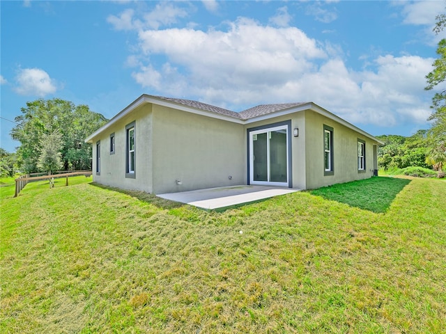 back of property featuring a patio area and a yard