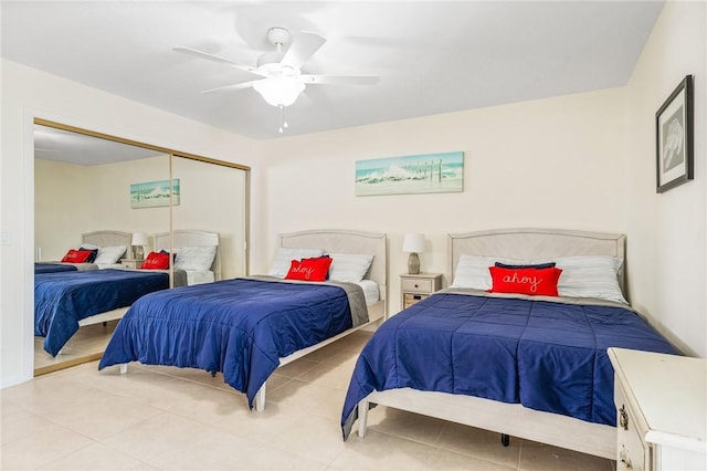 tiled bedroom with ceiling fan and a closet