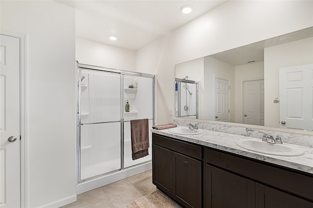 bathroom featuring tile patterned floors, vanity, and a shower with door