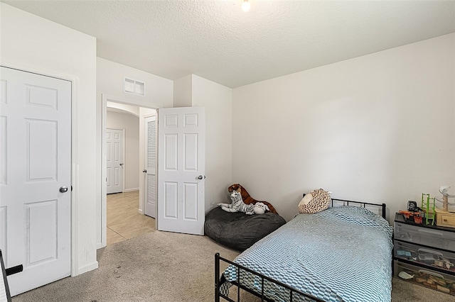 carpeted bedroom with a textured ceiling