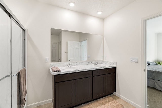 bathroom featuring a textured ceiling, vanity, and tile patterned floors