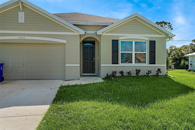 view of front facade with a front yard and a garage