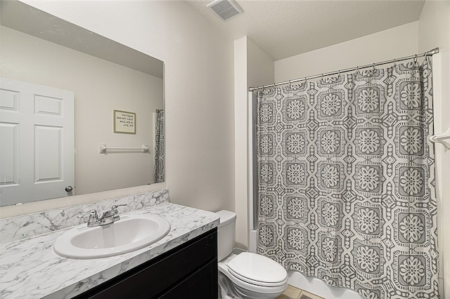 bathroom featuring vanity, a textured ceiling, and toilet