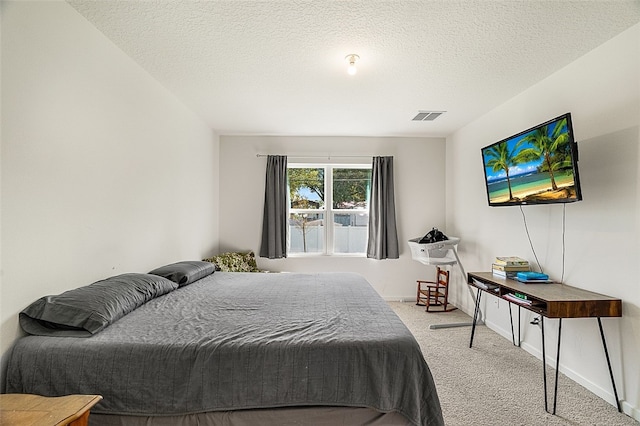 carpeted bedroom featuring a textured ceiling