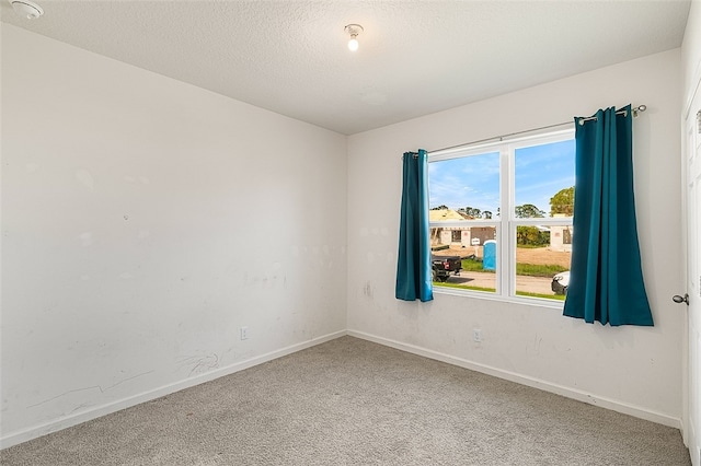 carpeted empty room with a textured ceiling