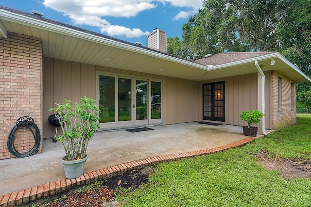 rear view of house with a patio and a lawn