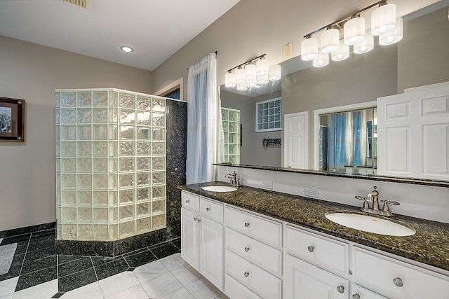 bathroom with a shower, vanity, and tile patterned flooring