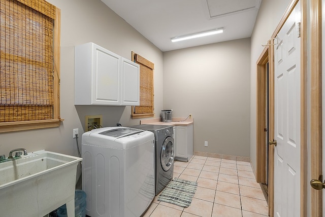 laundry area featuring cabinets, separate washer and dryer, sink, and light tile patterned floors