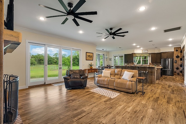 living room with ceiling fan, light hardwood / wood-style flooring, and crown molding