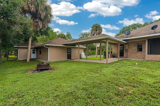 back of property with a patio area and a lawn