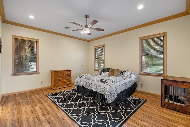 bedroom with hardwood / wood-style floors, ceiling fan, multiple windows, and ornamental molding