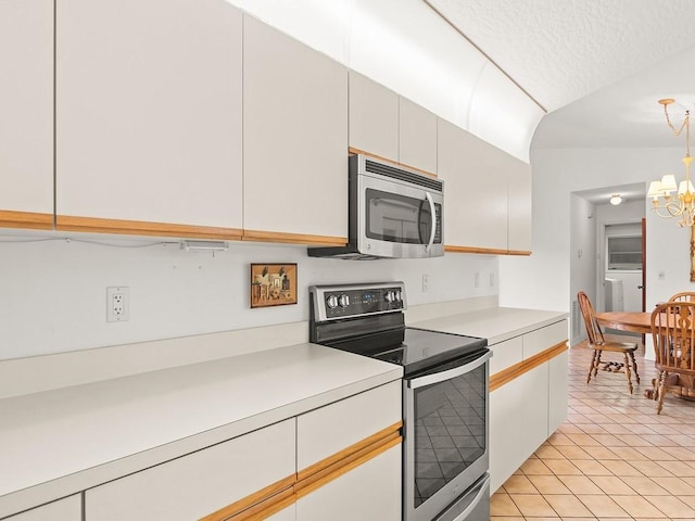 321 Browning Ter, Sebastian, FL 32958 - kitchen featuring appliances with stainless steel finishes, light countertops, a chandelier, light tile patterned floors, and lofted ceiling