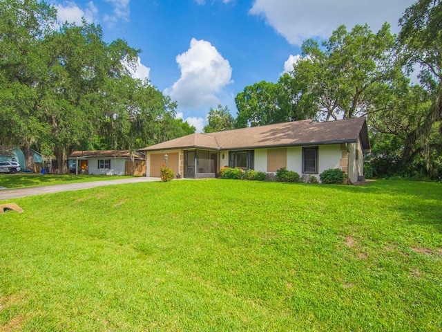 321 Browning Ter, Sebastian, FL 32958 - single story home featuring concrete driveway, an attached garage, a front lawn, a sunroom, and stucco siding