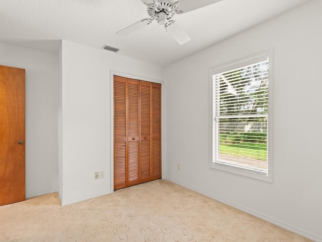 321 Browning Ter, Sebastian, FL 32958 - unfurnished bedroom with a closet, multiple windows, carpet floors, and ceiling fan