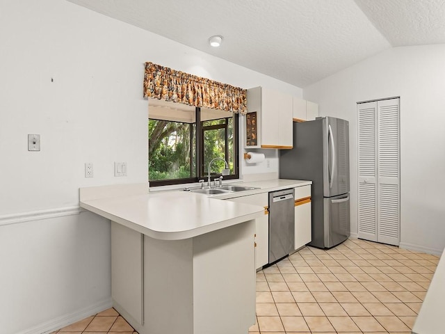 321 Browning Ter, Sebastian, FL 32958 - kitchen with stainless steel appliances, a peninsula, lofted ceiling, light countertops, and white cabinetry