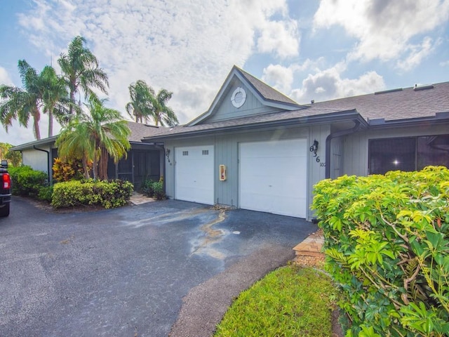 636 Centre Ct SW Unit 102, Vero Beach, FL 32962 - view of side of property with driveway, a garage, and roof with shingles