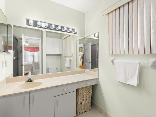 636 Centre Ct SW Unit 102, Vero Beach, FL 32962 - bathroom featuring connected bathroom, vanity, ceiling fan, and baseboards