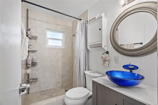 bathroom featuring tile patterned floors, toilet, vanity, and walk in shower