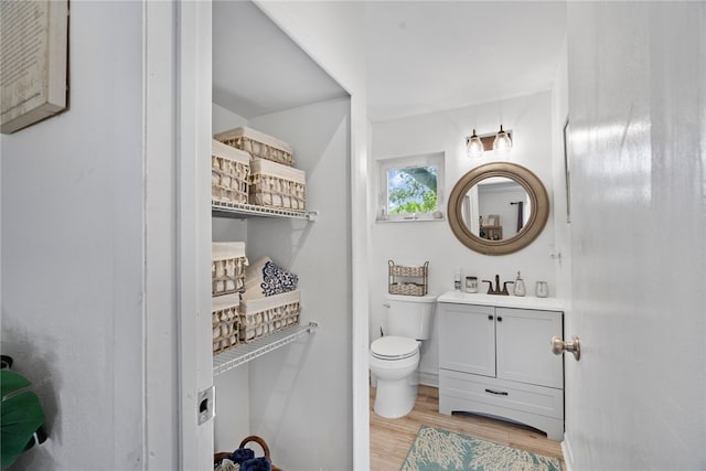 bathroom with hardwood / wood-style floors, vanity, and toilet