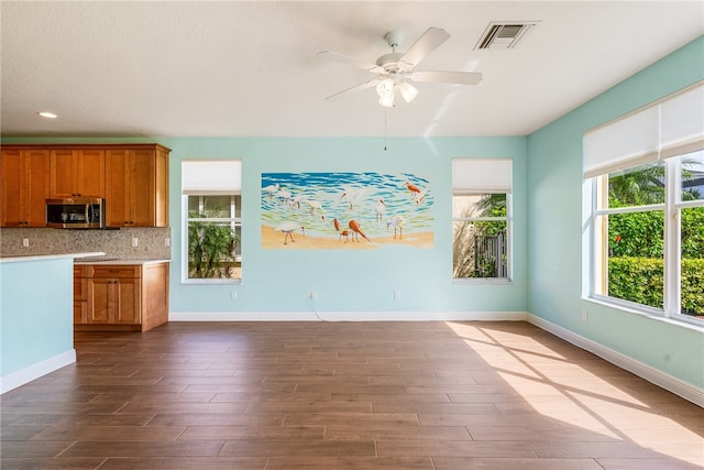 kitchen with hardwood / wood-style floors, ceiling fan, and backsplash