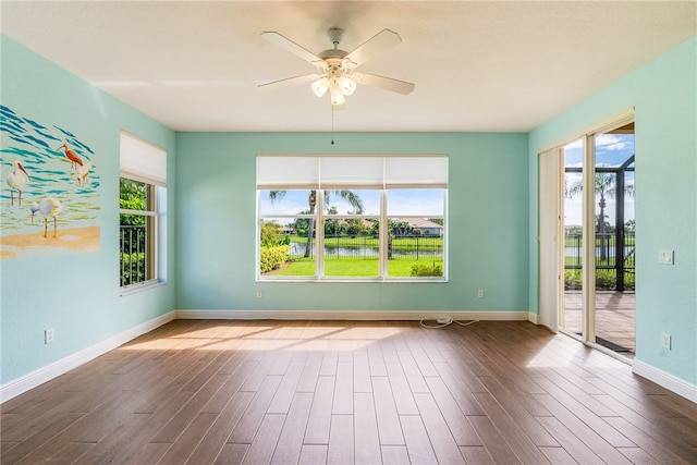 empty room featuring plenty of natural light, ceiling fan, and wood-type flooring