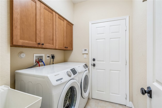 washroom with separate washer and dryer, sink, light tile patterned floors, and cabinets