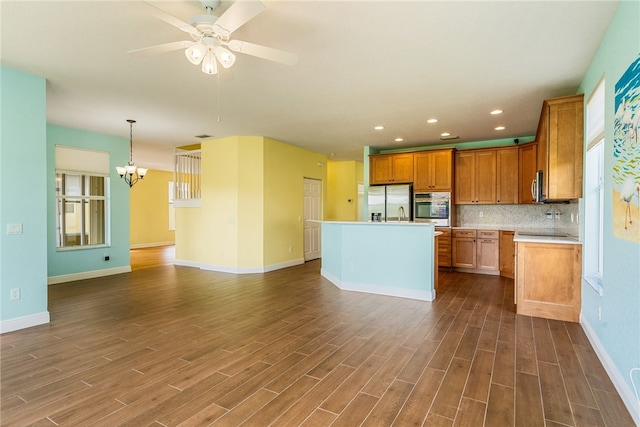 kitchen featuring hanging light fixtures, dark hardwood / wood-style flooring, a center island, and stainless steel appliances