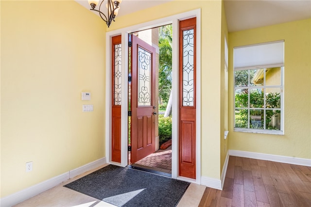 entryway featuring light hardwood / wood-style flooring, a healthy amount of sunlight, and a notable chandelier