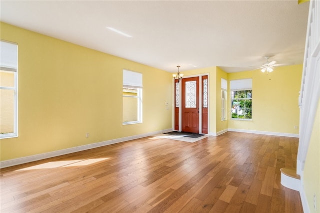 foyer featuring light hardwood / wood-style flooring and ceiling fan with notable chandelier