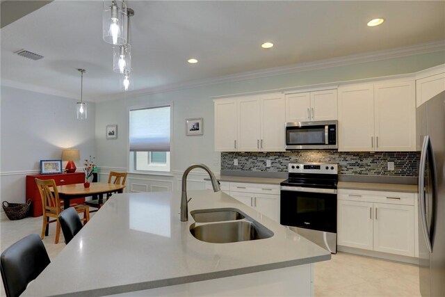 6005 Bella Rosa Ln, Vero Beach, FL 32966 - kitchen with stainless steel appliances, a sink, white cabinets, pendant lighting, and crown molding
