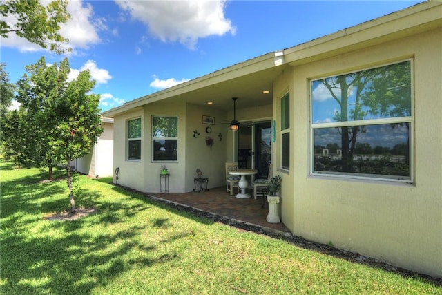6005 Bella Rosa Ln, Vero Beach, FL 32966 - back of property with ceiling fan, stucco siding, a yard, and a patio area